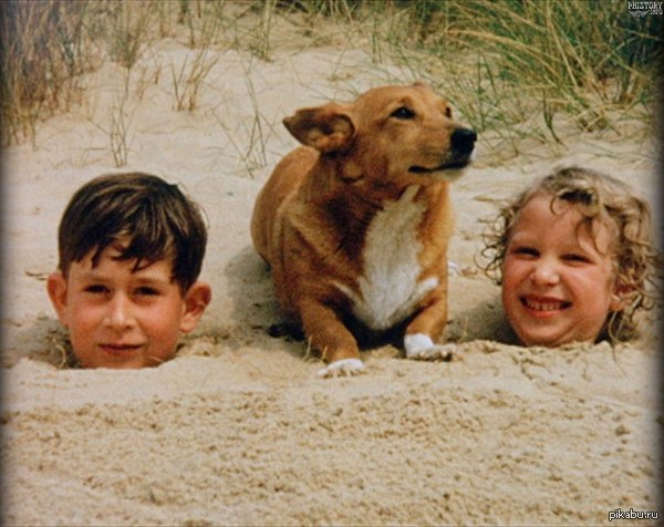 Prince Charles and Princess Anne are buried in the sand on the beach. - Historical photo, Prince Charles, Queen Elizabeth II, Great Britain, King Charles III (Prince Charles)
