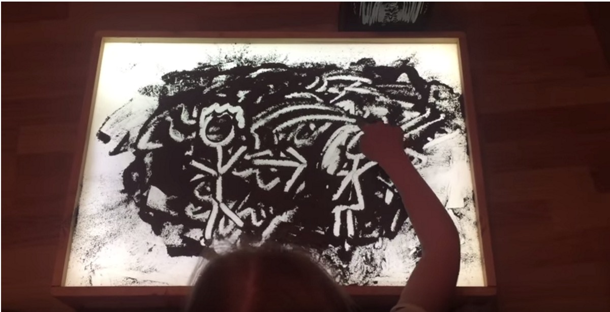 случайно пролил. девочка рисует прахом деда.